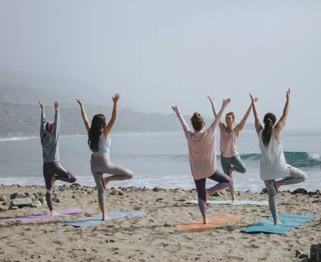 five woman working out on beach