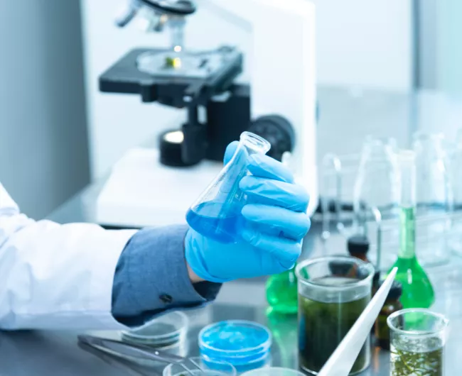 man holding beaker in lab