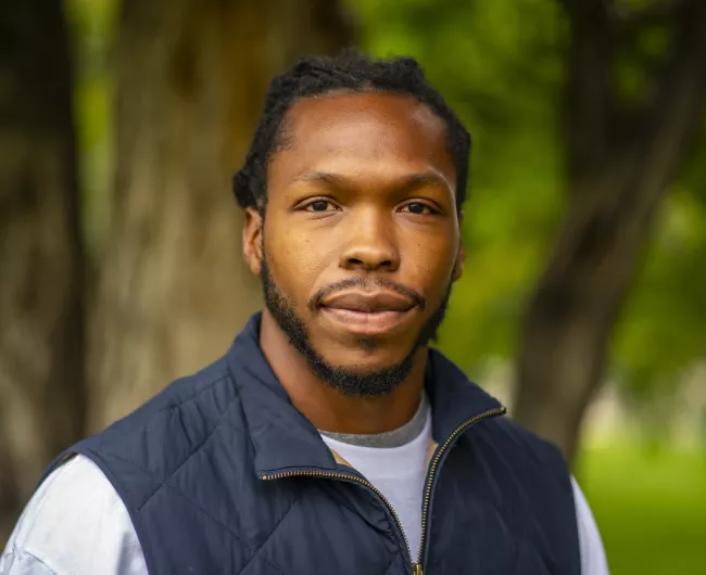 young black man in blue vest