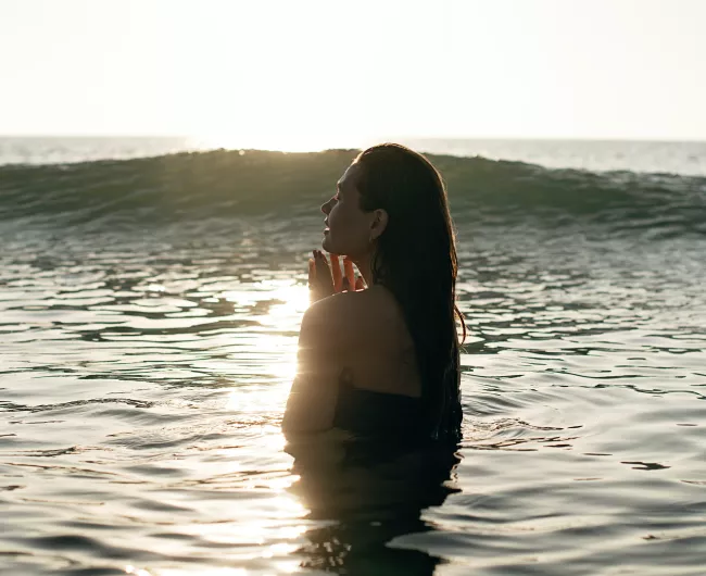 young woman standing in ocean